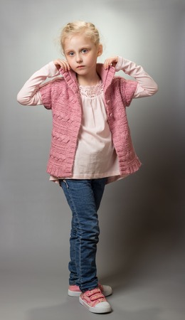 Charming little fashionista in jeans on grayの写真素材