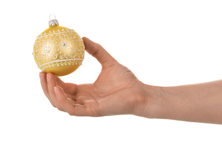 Christmas toy ball with designs and rhinestones in female hand isolated on whiteの写真素材