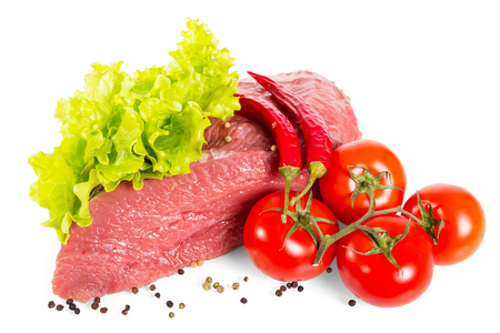 Piece of fresh veal, lettuce leaves, tomatoes and pepper isolated on whiteの写真素材