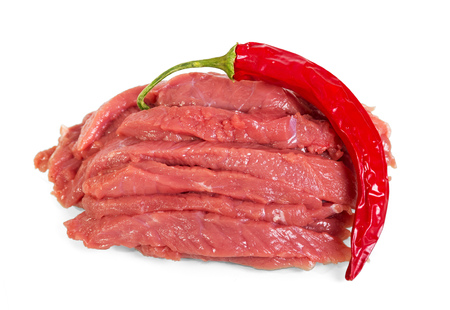 Fresh meat, veal pieces and chili peppers isolated on whiteの写真素材