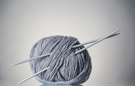 Coil of gray yarn and needles for needlework, on grayの写真素材