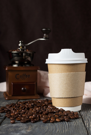 Container with lid for takeaway coffee, near coffee beans and millの写真素材