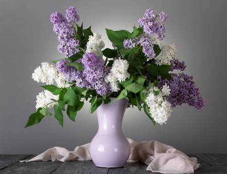 Charming bouquet of white and lilac flowers in vase on grayの写真素材