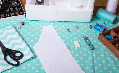 Sewing machine, removable presser feet and accessories, paper pattern on fabric for cutting
