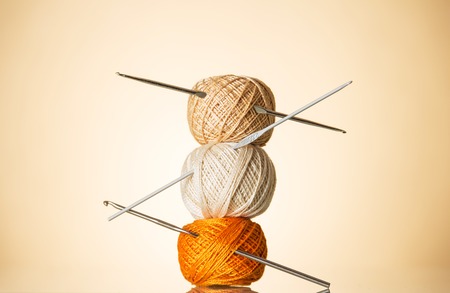 Three skein of cotton yarn of different shade, knitting hooks, on beigeの写真素材