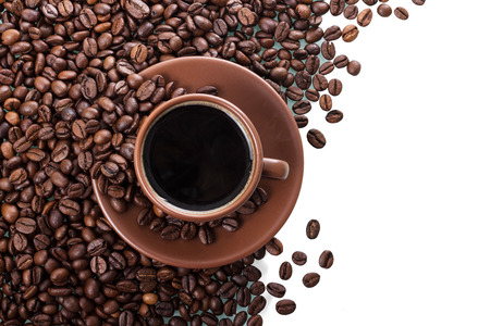 Cup of coffee and saucer on background of coffee beansの写真素材
