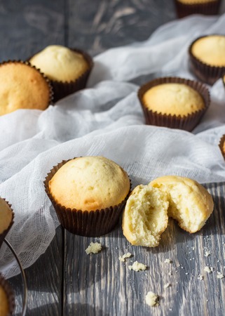 Freshly baked cupcakes in molds on background of thin airy fabricの写真素材