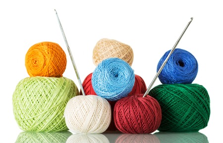 Cotton yarn balls of different shades and crochet hooks, isolated on whiteの写真素材