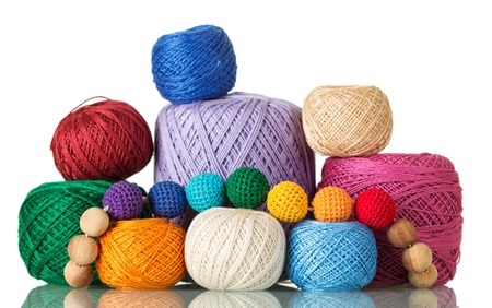 Large and small balls of multi-colored yarn, beads of thread, isolated on whiteの写真素材