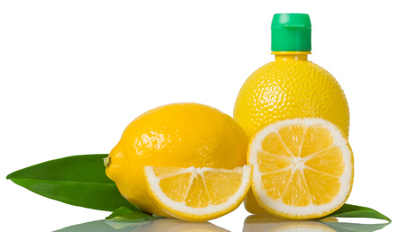 Lemon juice in bottle, whole fruit and pieces isolated on whiteの写真素材