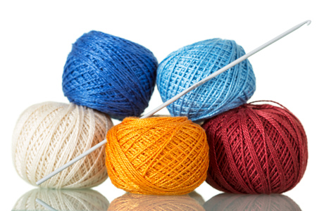 Colored tangles of cotton yarn and crochet hook, isolated on whiteの写真素材