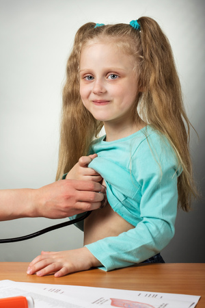 Little girl at doctors reception, on grayの写真素材