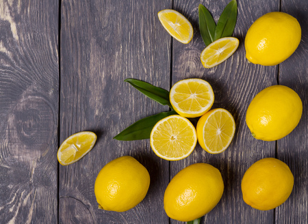 Lots of big yellow lemons and pieces, on grey surfaceの写真素材