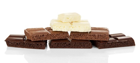 Pieces of black porous, milk and white chocolate isolated on whiteの写真素材