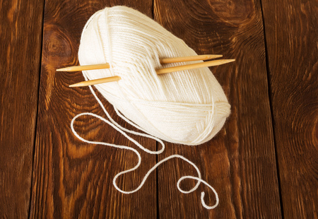 Hank of soft yarn and wooden knitting needles, on tableの写真素材