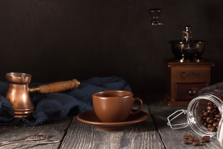 Coffee teapot, Cup and saucer and jar with coffee beans, isolated on blackの写真素材