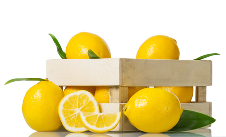 Lemons in box, near whole citrus and pieces isolated on whiteの写真素材