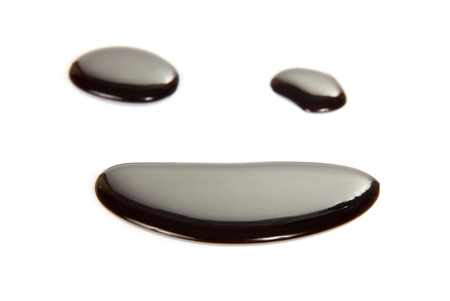 Smile from melted dark chocolate isolated on whiteの写真素材