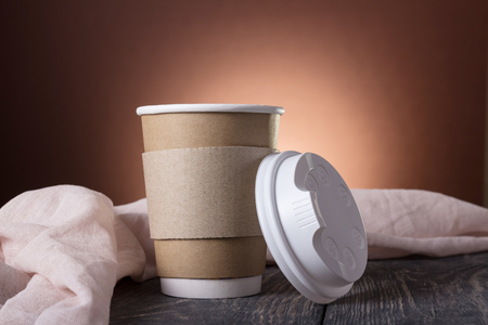 Cup-thermos with lid for coffee to take away, on background of wooden tableの写真素材