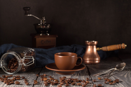 Cup and saucer, scattered coffee beans, coffee maker, isolated on blackの写真素材