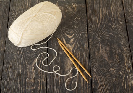 Soft beige yarn Hank for hand knitting and knitting needles, on background of dark surfacesの写真素材