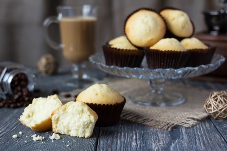 Cupcakes on glass dish, next to broken cupcake, on gray surfaceの写真素材