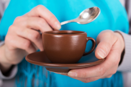 Cup of coffee and spoon in womens handsの写真素材
