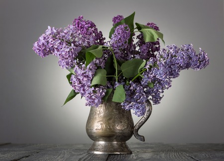 Bouquet of lilac in an old vase, on gray backgroundの写真素材