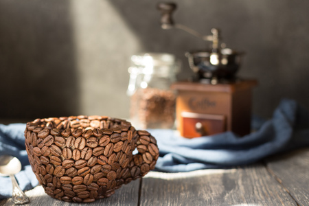 Cup made of coffee beans, standing on gray wooden tableの写真素材