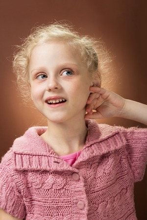 Pretty face of little curly-haired blondes with smile, depicted close upの写真素材