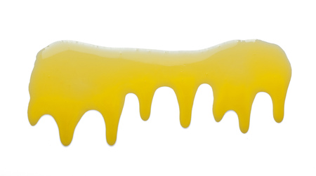 Puddle of fresh spring honey is spread, isolated on whiteの写真素材