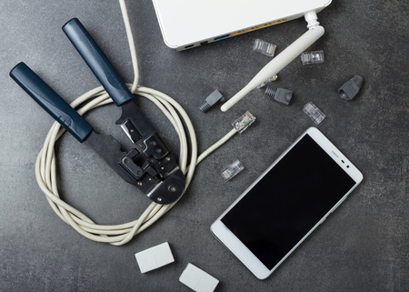 Router, cable to connect, smartphone and pliers for crimping connectors on surfaceの写真素材