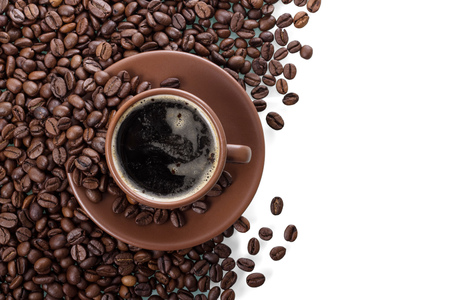 Scattered coffee beans and a Cup of coffee with foam isolated on whiteの写真素材