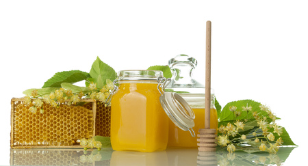 Two pots with honey, wooden spoon and honeycomb isolated on whiteの写真素材