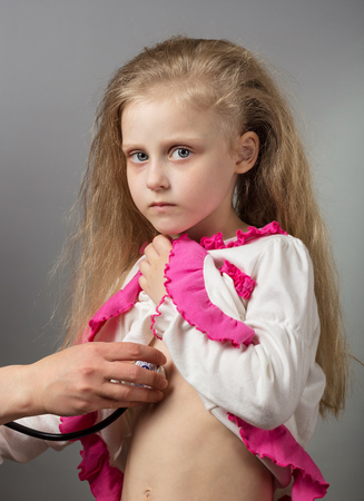 Sick child at doctors reception, on grayの写真素材