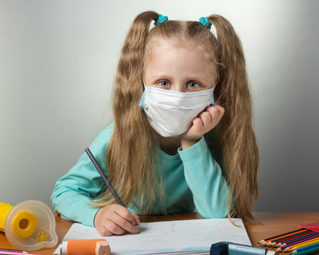Little sick girl in protective bandage draws, on gray backgroundの写真素材