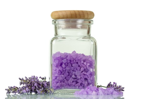 Glass jar with sea salt, near lavender sprigs isolated on whiteの写真素材