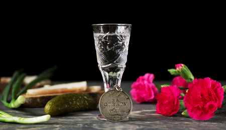 Medal of valor, red carnations and glass of vodka, isolated on black backgroundの写真素材