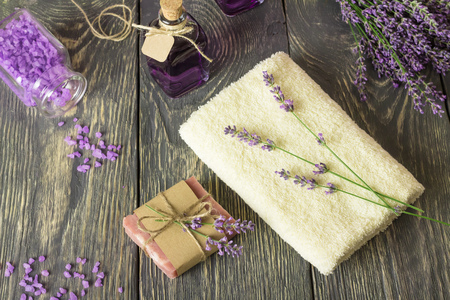 Handmade soap, sea salt and lavender tincture, towel on wooden surfaceの写真素材