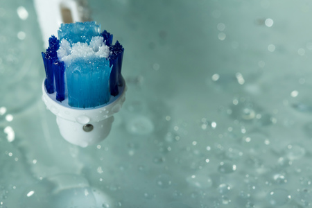 Bristles of electric toothbrush against the background of water dropletsの写真素材