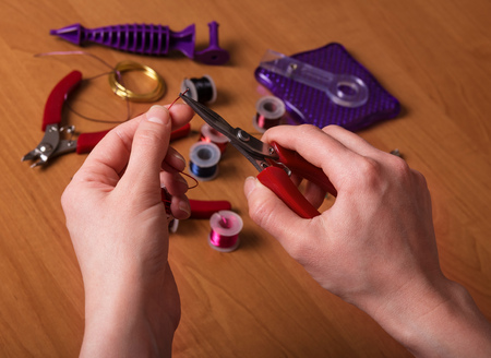 Handmade braiding from wire. Tongs and other accessories on the desktopの写真素材