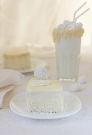 Coconut cake, a delicious milkshake in a glass decorated with chocolate on white backgroundの写真素材