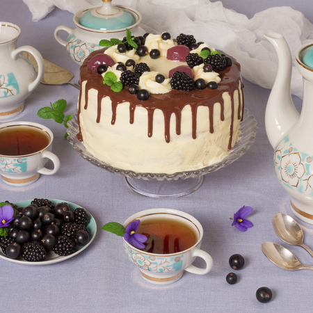A festive table. Beautiful delicious cake with berries and hot herbal teaの写真素材