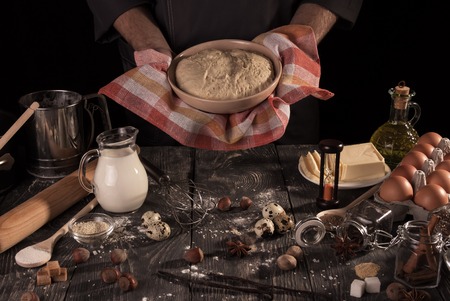 Chef man holding the bowl of yeast dough in the kitchenの写真素材
