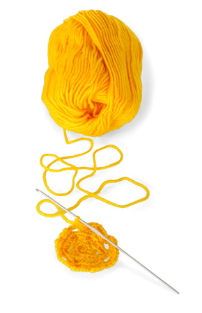 Hank of yellow wool yarn and crochet the product isolated on white backgroundの写真素材