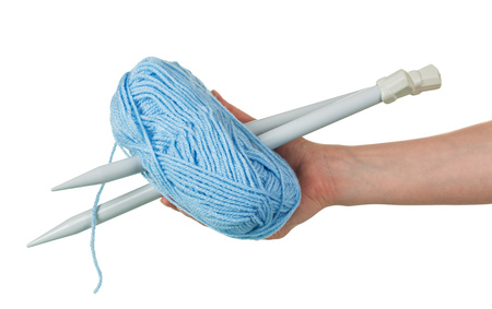 Blue skein of wool and knitting needles in female hands isolated on white backgroundの写真素材
