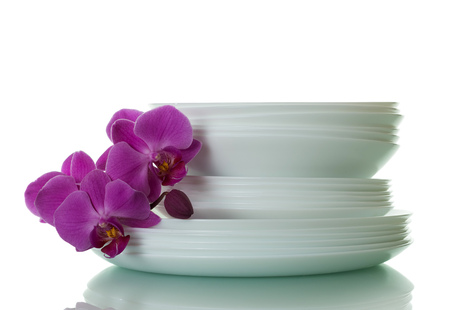 Set clean plates and an orchid branch isolated on white backgroundの写真素材