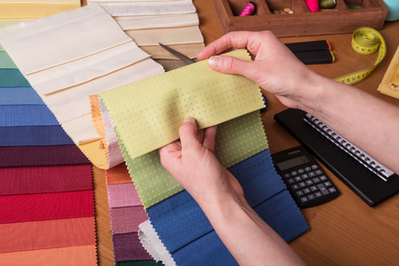 Cabin curtains. Salesman showing fabric samples for curtains, helps with the selectionの写真素材