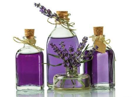 Three bottles with a fragrant tincture of lavender and fresh twigs isolated on white backgroundの写真素材