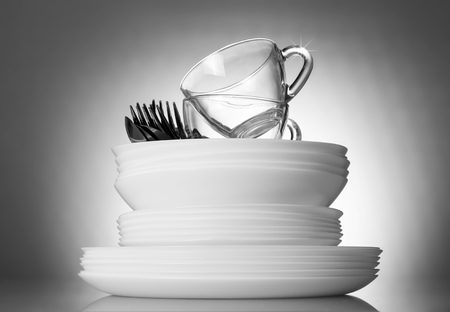 Clean plates and cutlery on a bright beautiful gray backgroundの写真素材
